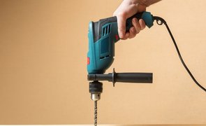 mão segurando furadeira elétrica
