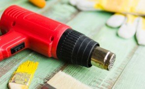 soprador térmico ao lado de pincel com tinta amarela