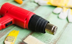 soprador térmico ao lado de pincel com tinta amarela
