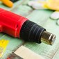 soprador térmico ao lado de pincel com tinta amarela soprador térmico ao lado de pincel com tinta amarela